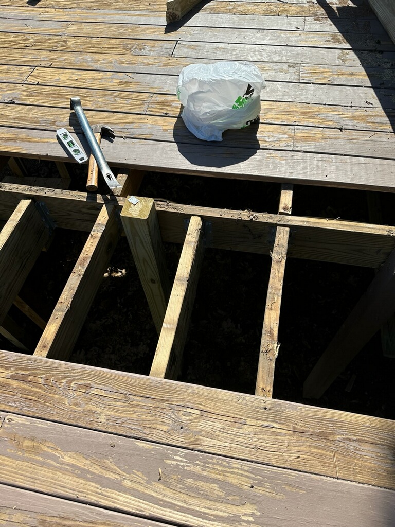 Old rotted deck boards torn up before rebuild