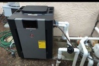 Pool heater installation — new heater set with plumbing lines staged for hookup